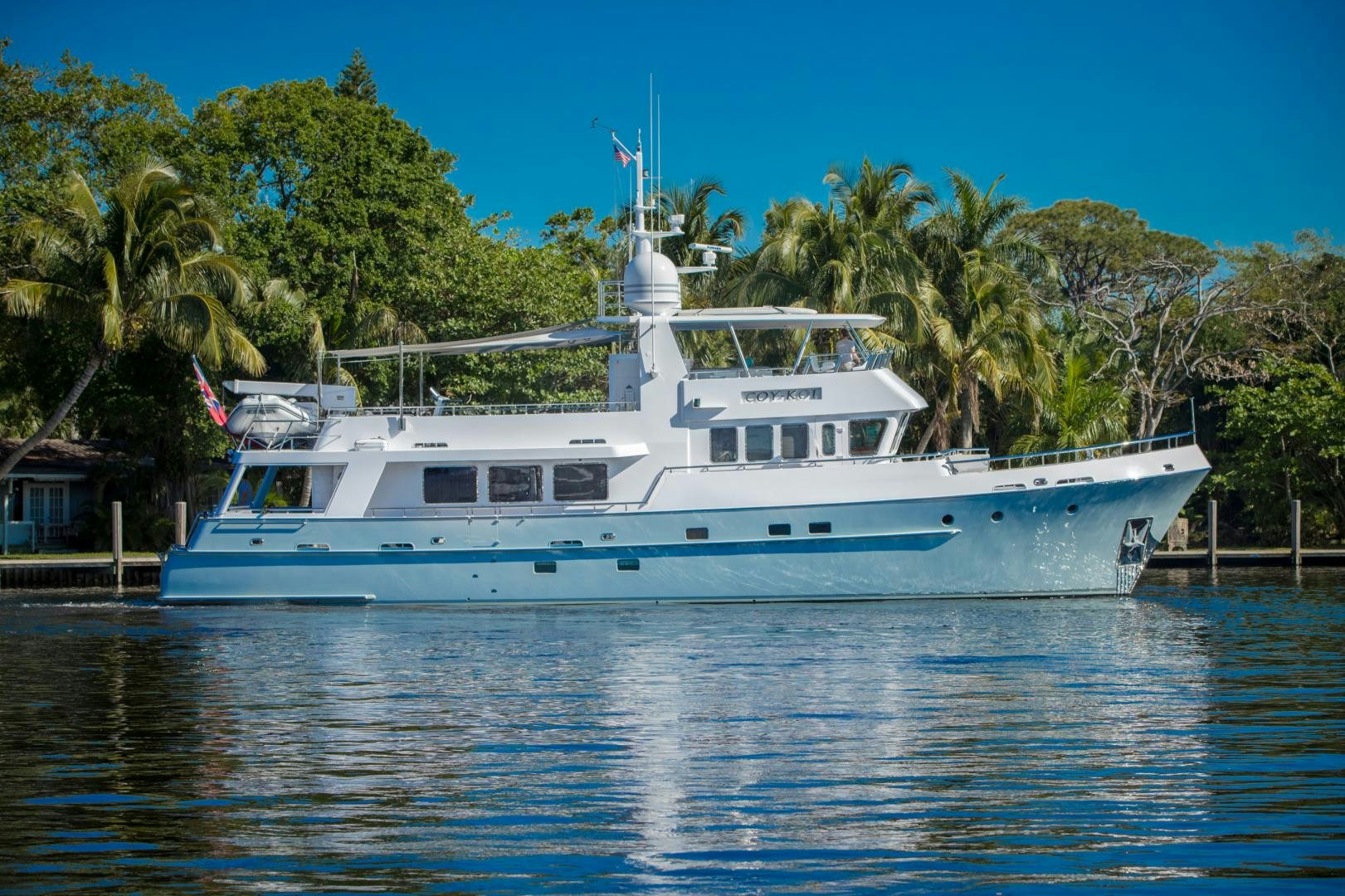 a large white boat in a harbor aboard SLOW POKE Yacht for Sale