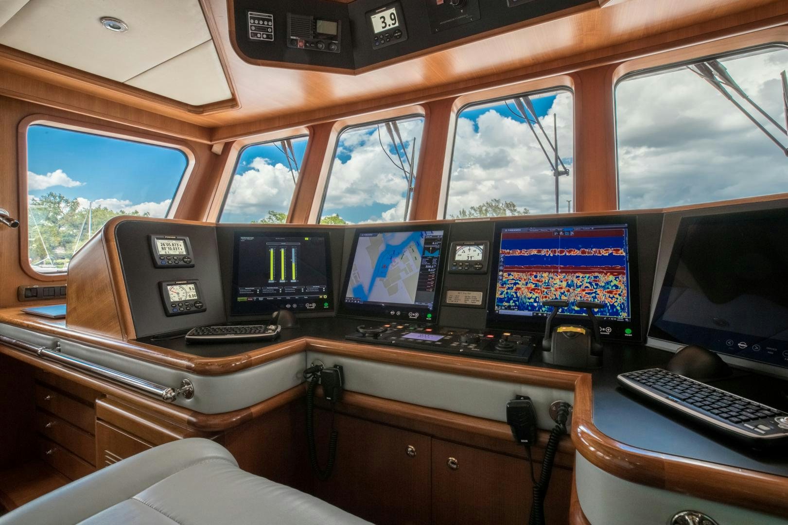 a room with many monitors and keyboards aboard SLOW POKE Yacht for Sale