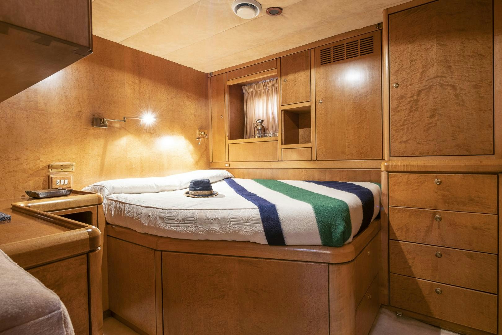 a bedroom with a bed and a dresser aboard ROCIO Yacht for Sale