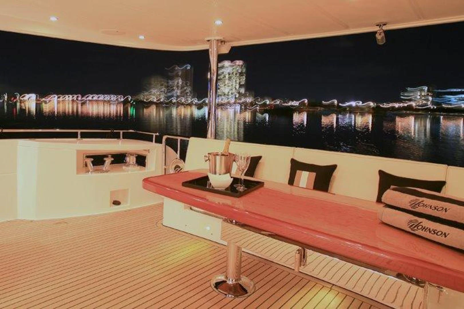 a table with chairs on it aboard JOHNSON 80' FLYBRIDGE W/FISHING COCKPIT Yacht for Sale