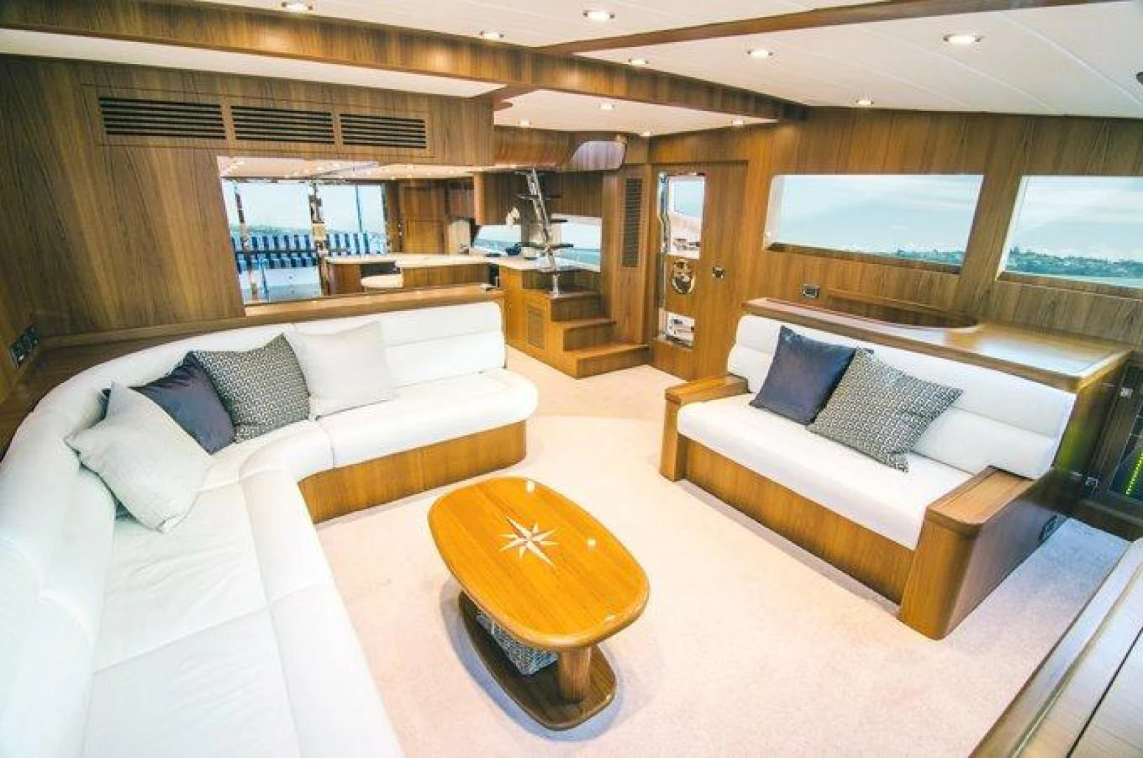 a living room with a couch and a table aboard JOHNSON 80' FLYBRIDGE W/FISHING COCKPIT Yacht for Sale