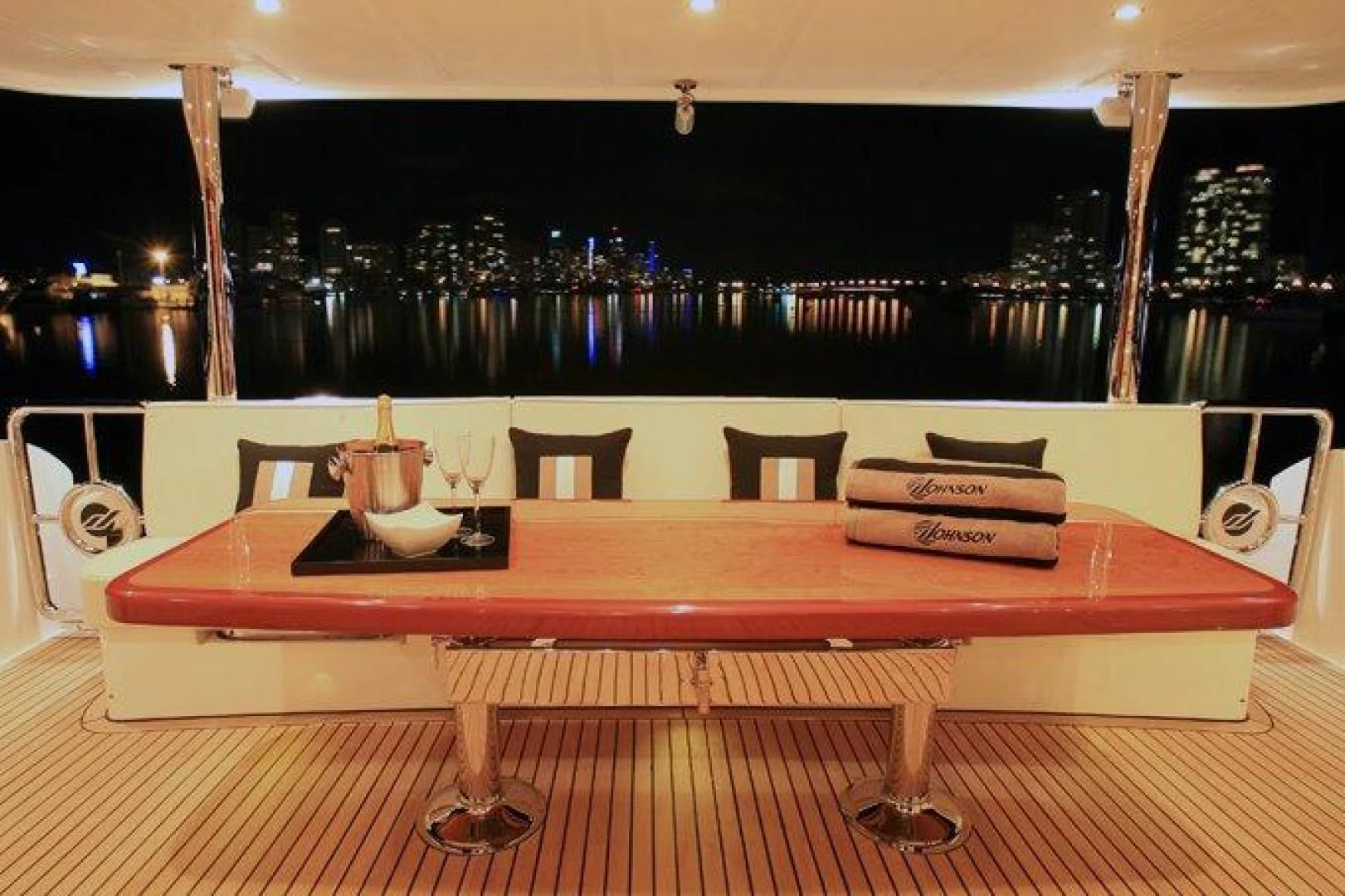 a table with chairs around it aboard JOHNSON 80' FLYBRIDGE W/FISHING COCKPIT Yacht for Sale