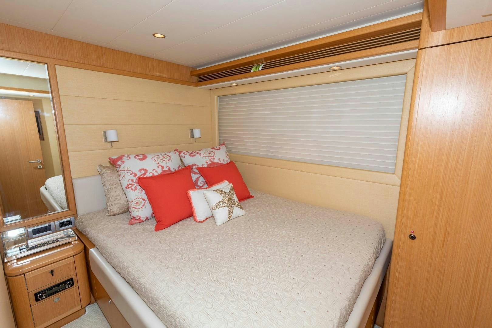 a bed with red pillows aboard MI RX Yacht for Sale