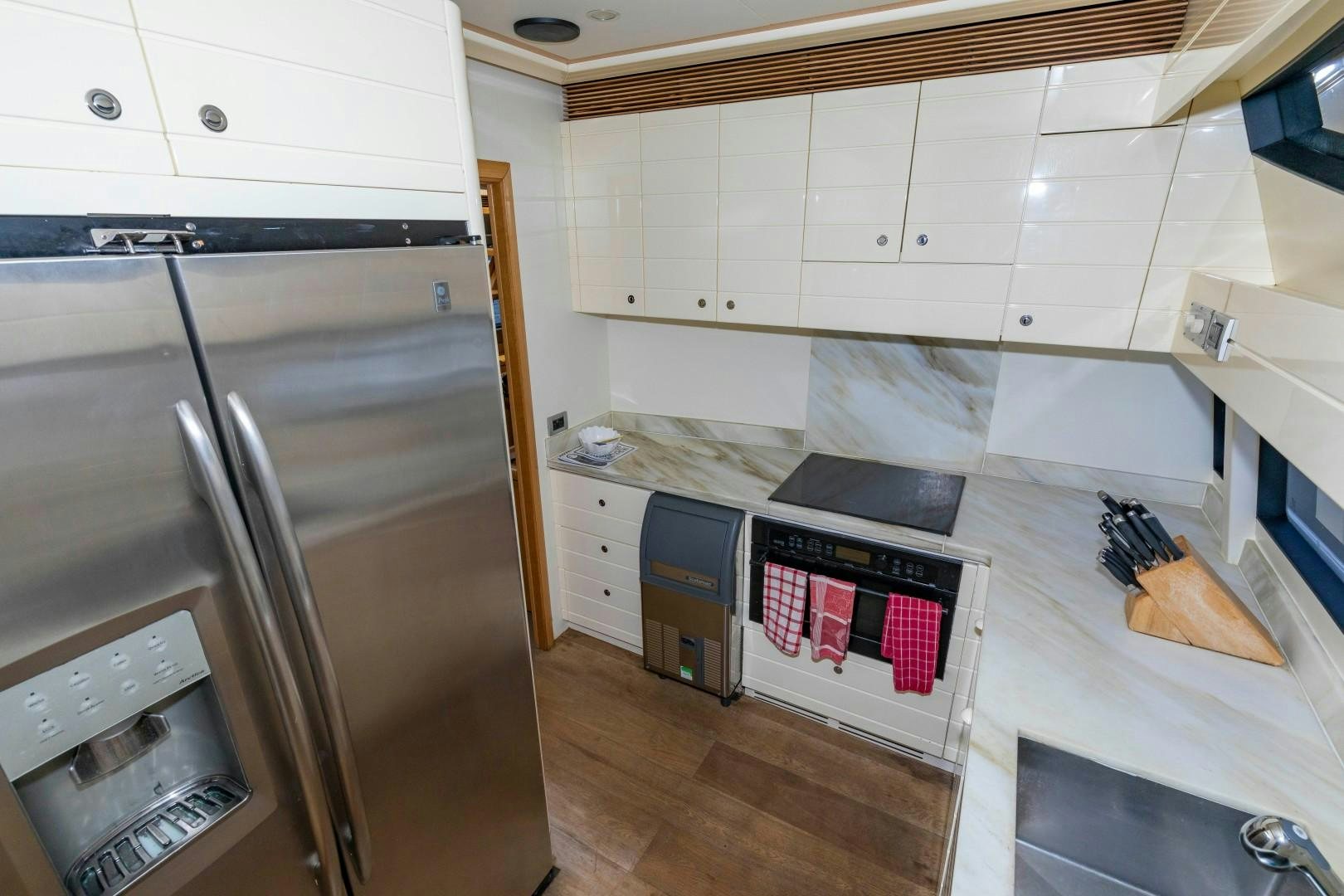 a kitchen with white cabinets aboard MI RX Yacht for Sale
