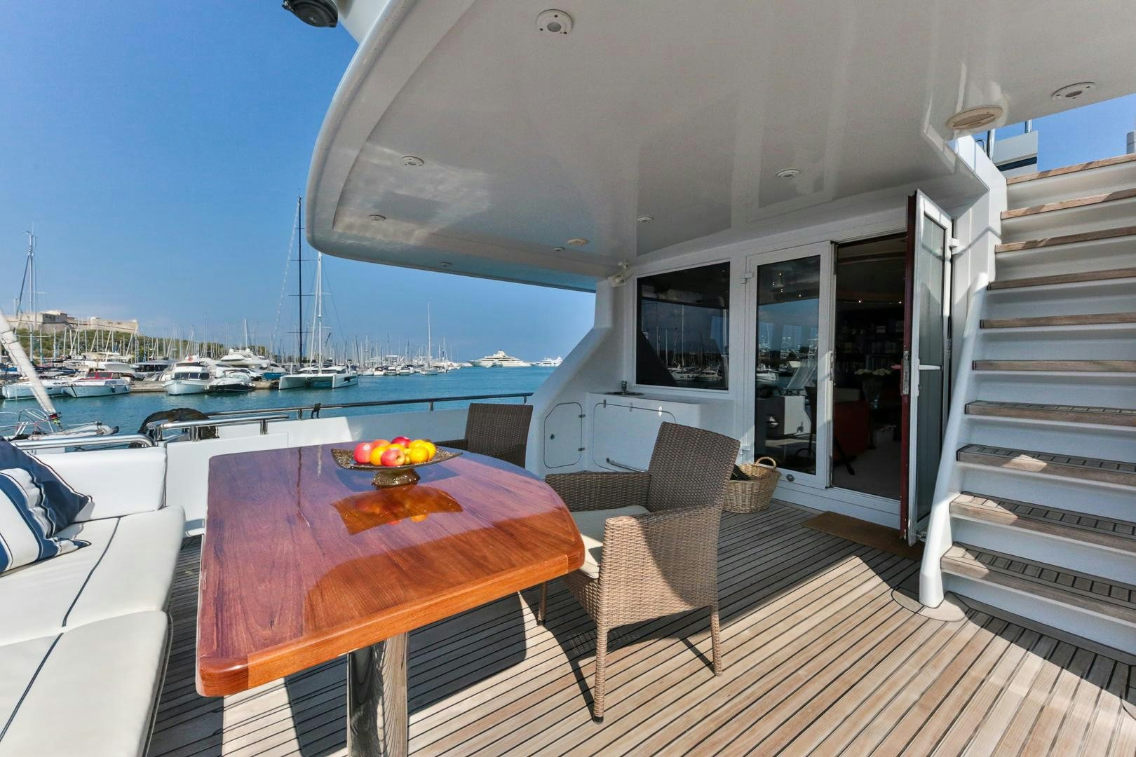 a deck with a table and chairs on it aboard HAPPY DAZE Yacht for Sale