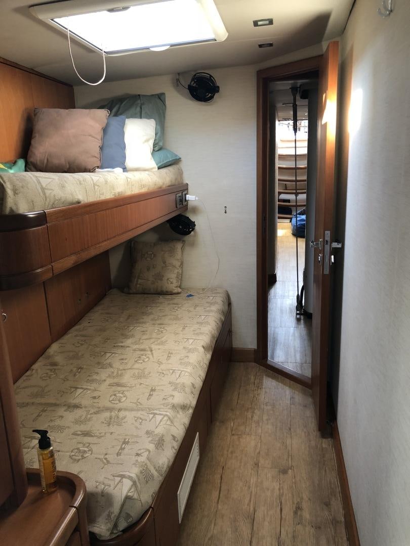 a bedroom with a bed and a door aboard INDIGO Yacht for Sale