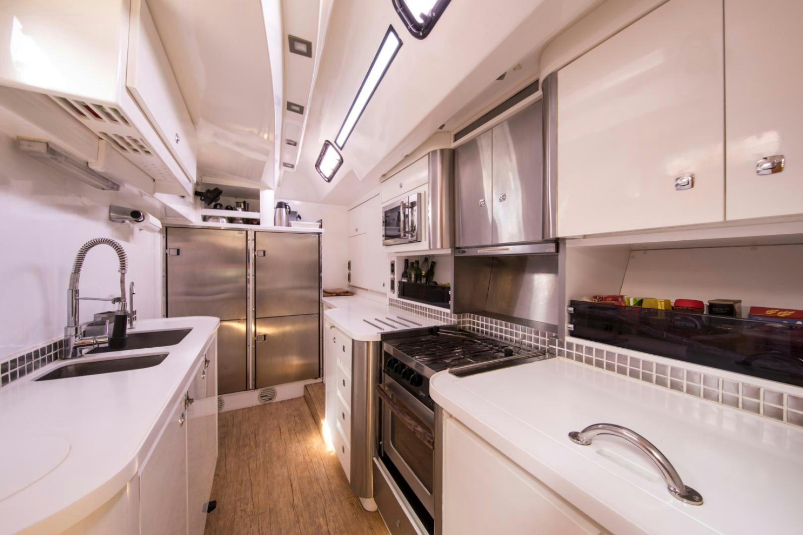 a kitchen with white cabinets aboard INDIGO Yacht for Sale