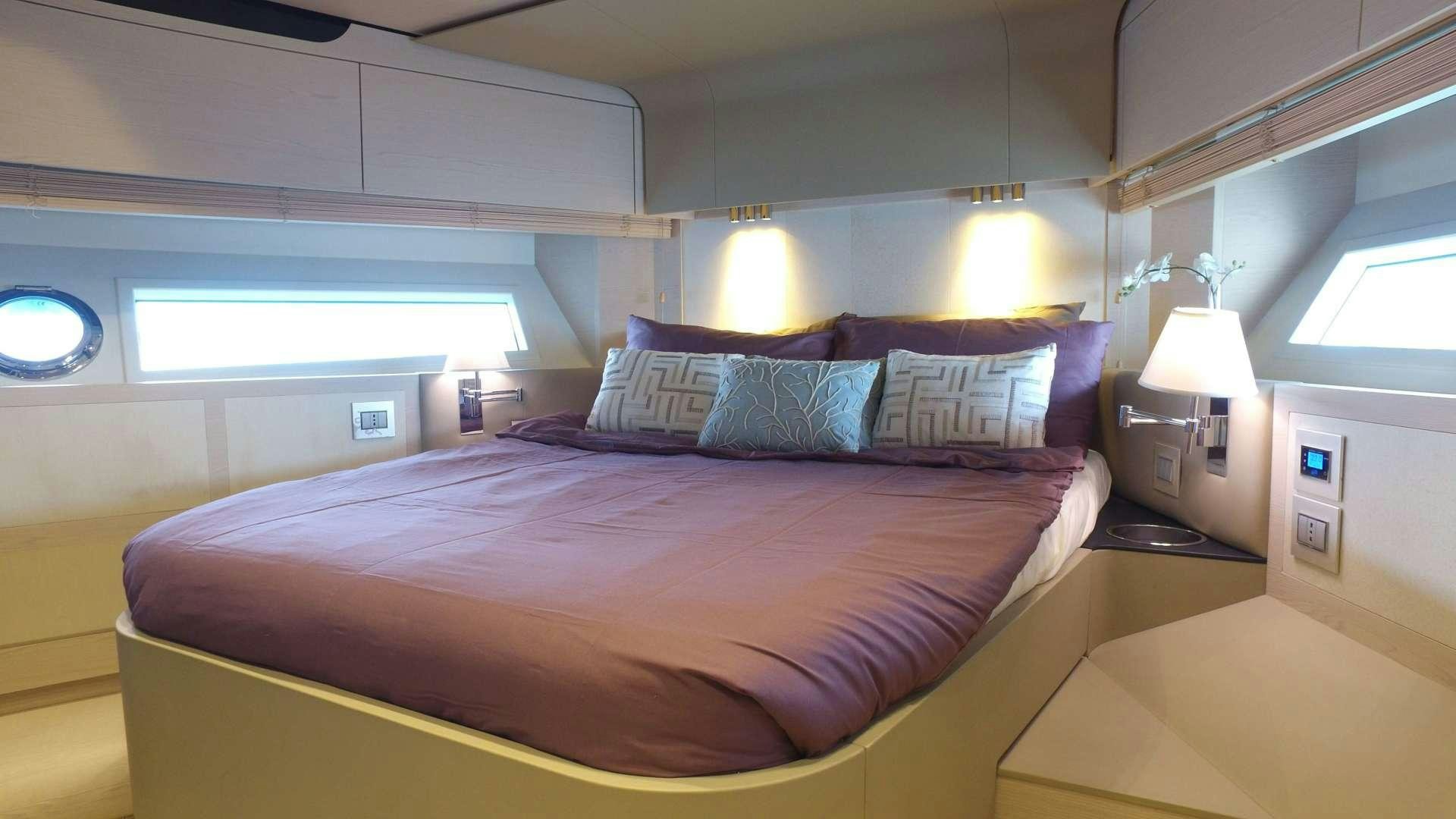 a bed with a purple comforter aboard OKS Yacht for Sale