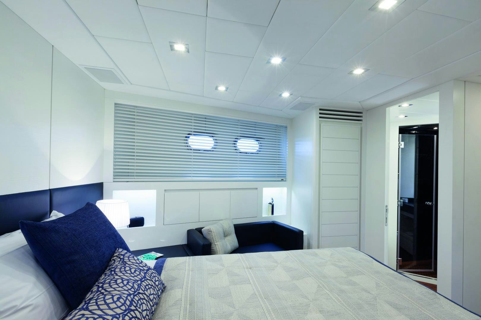 a large white bedroom with a large bed and a large white wall aboard MY TOY Yacht for Sale