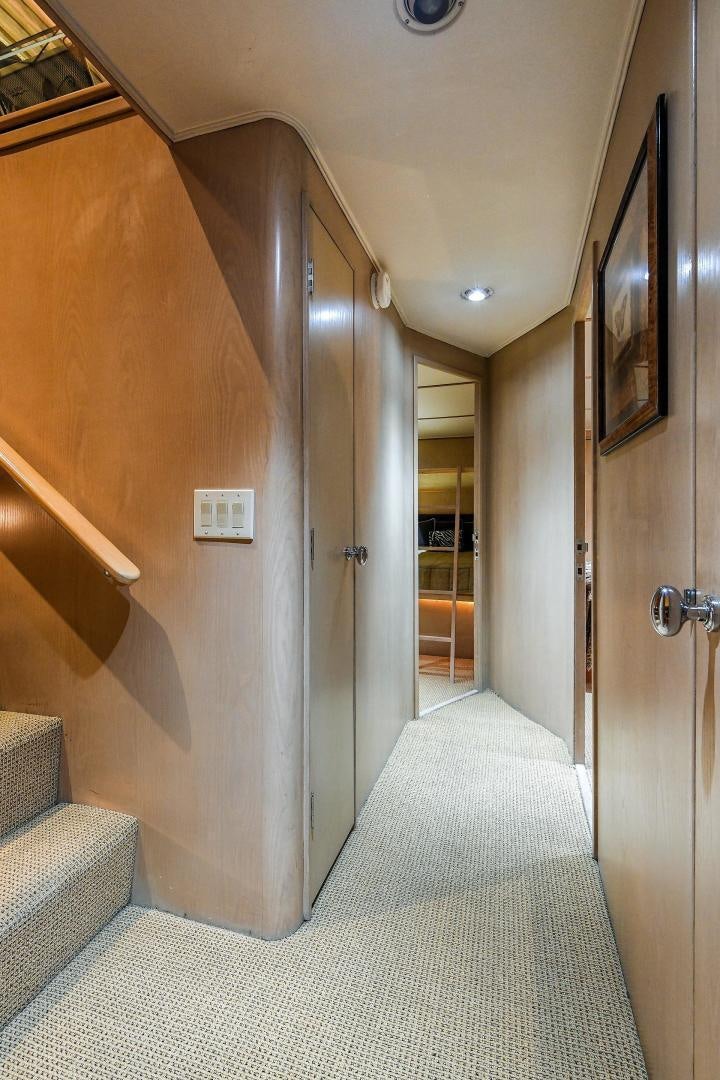 a hallway with a door and a rug aboard PRIMETIME III Yacht for Sale