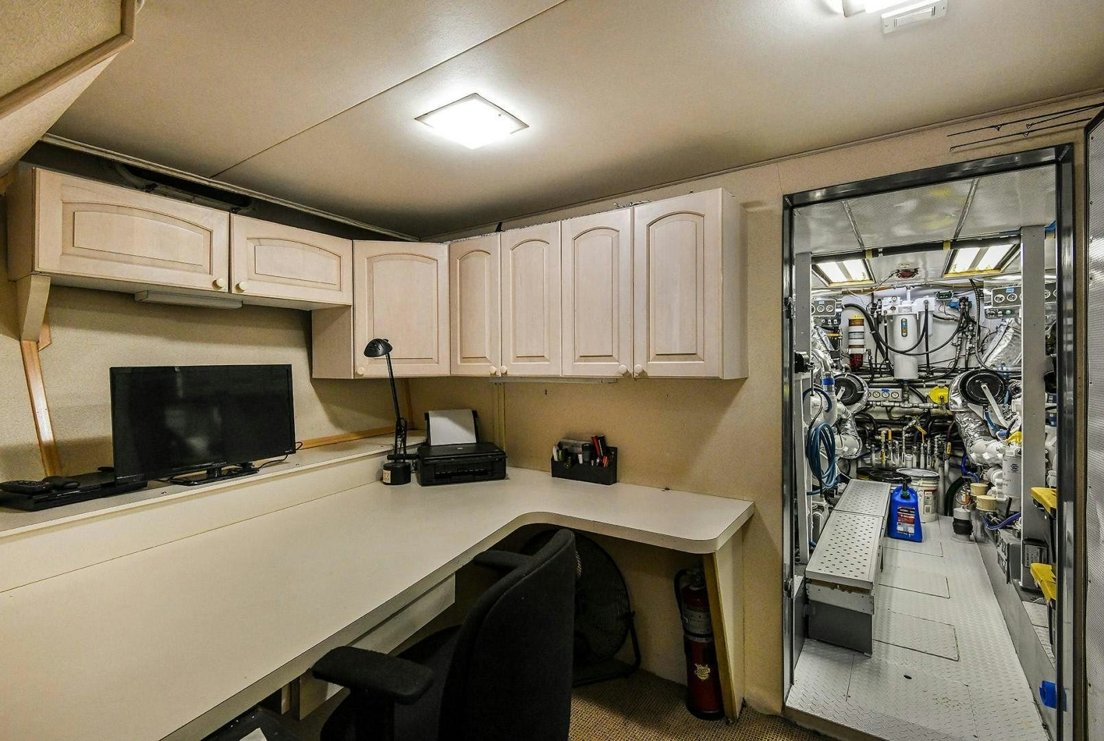 a room with a computer and a television aboard PRIMETIME III Yacht for Sale