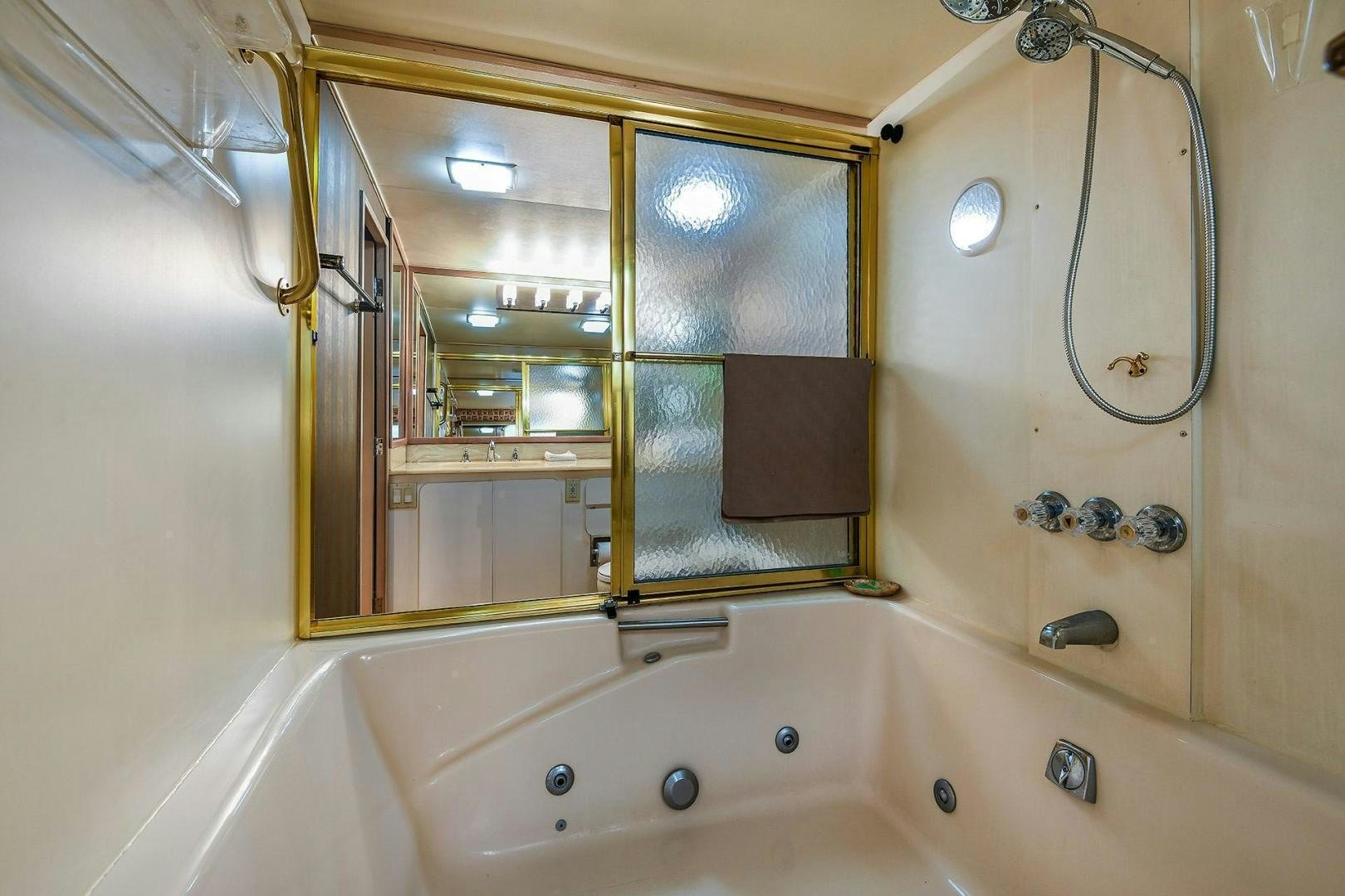 a bathtub with a shower head aboard PRIMETIME III Yacht for Sale