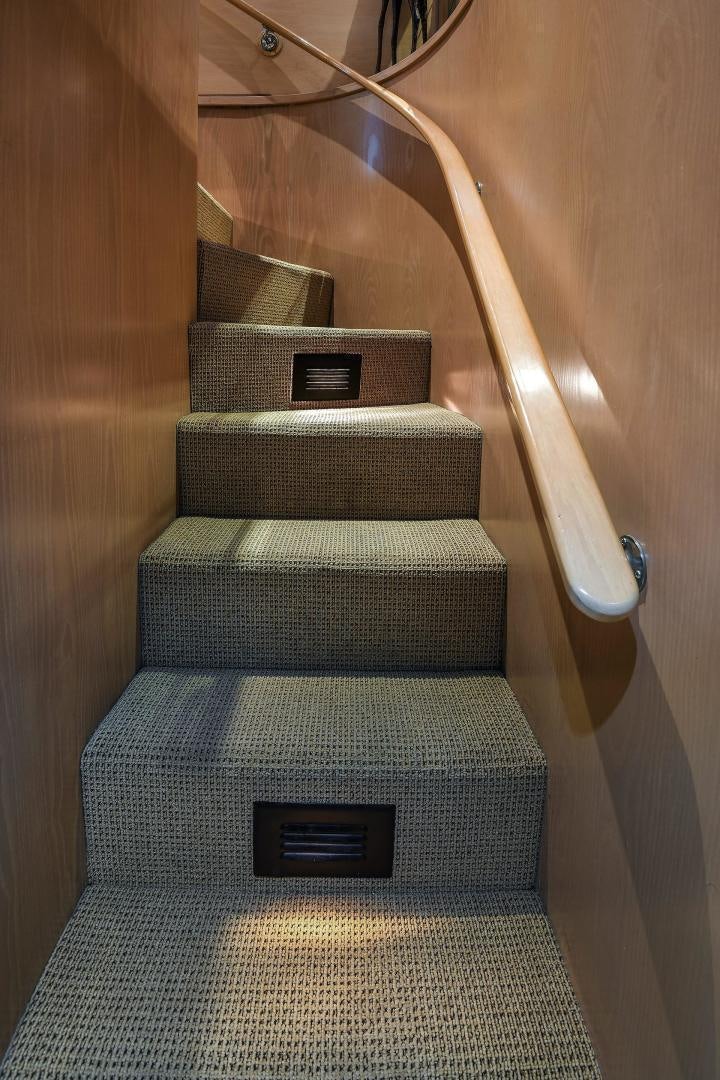 a staircase with a wood railing aboard PRIMETIME III Yacht for Sale