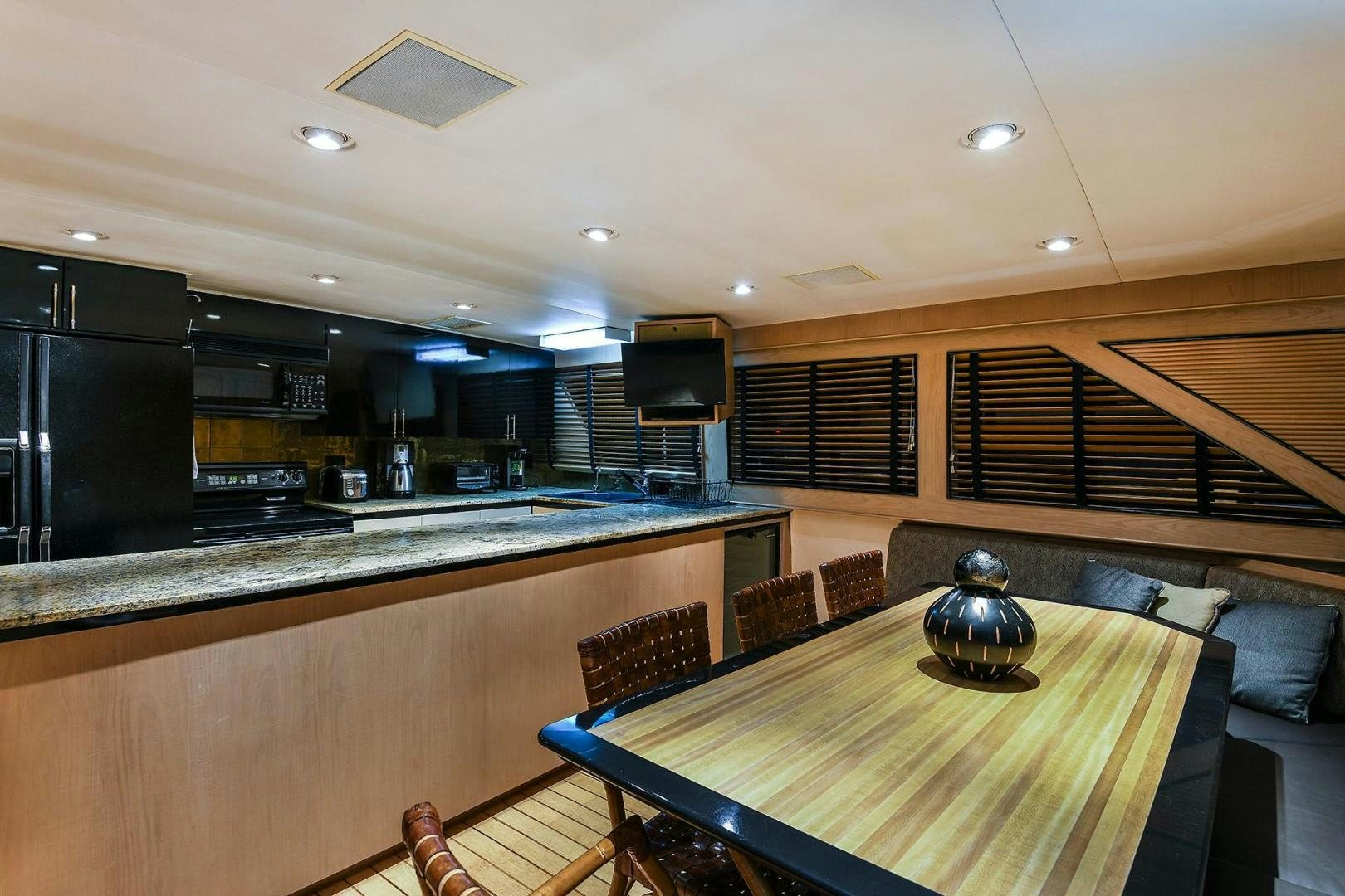 a kitchen with a table and chairs aboard PRIMETIME III Yacht for Sale