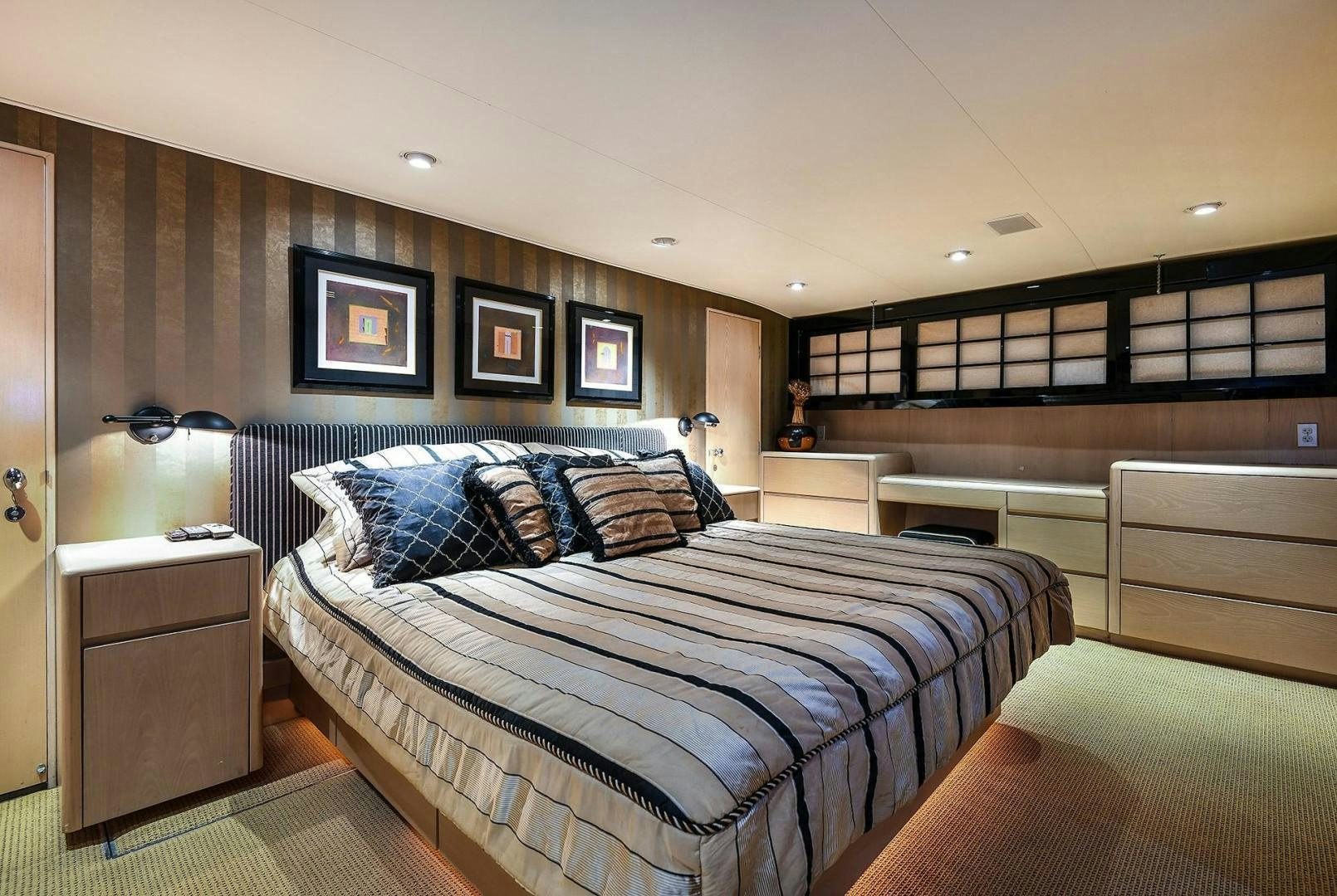 a bedroom with a bed and a desk aboard PRIMETIME III Yacht for Sale