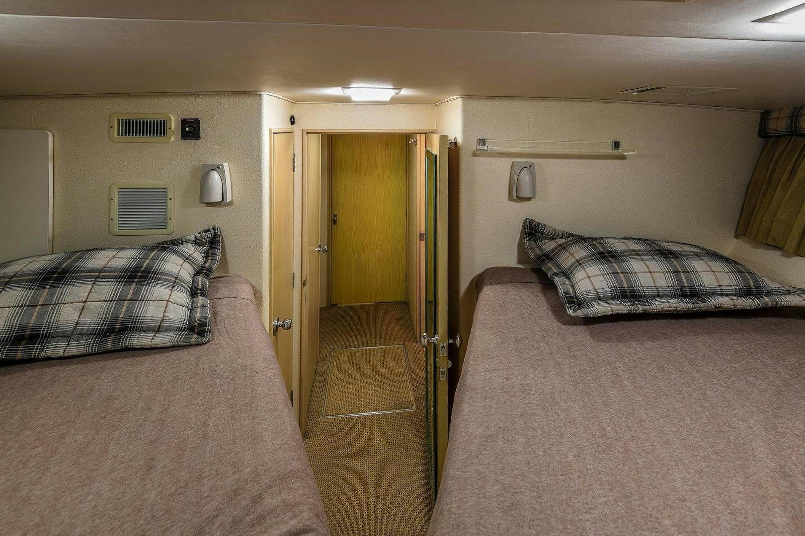 a bedroom with a bed and a door aboard PRIMETIME III Yacht for Sale
