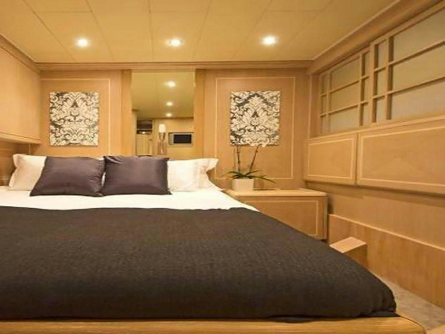 a bed with a black and white bed spread aboard COTE D’AZURE Yacht for Sale