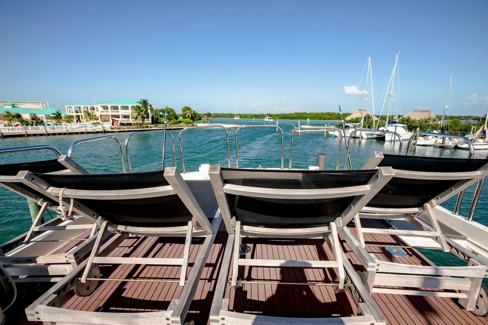 a deck with chairs and boats aboard CATCHIN FEELINGS Yacht for Sale