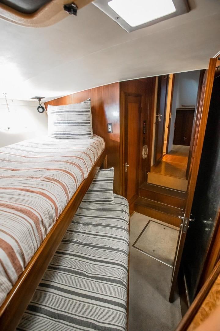 a bedroom with a wood floor aboard CATCHIN FEELINGS Yacht for Sale