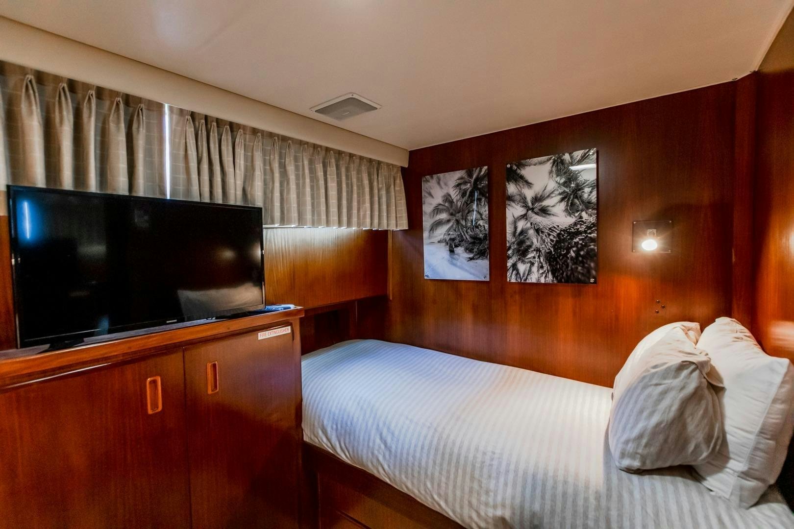 a hotel room with a bed and a tv aboard CATCHIN FEELINGS Yacht for Sale