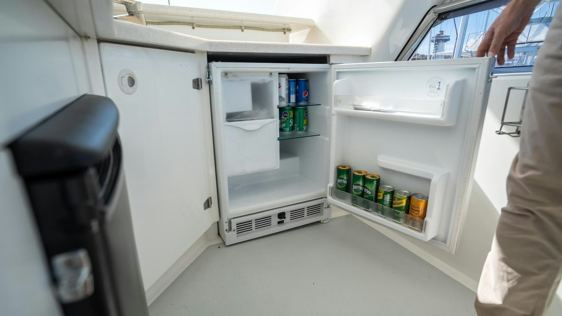 a person opens a refrigerator aboard FULL HOUSE Yacht for Sale