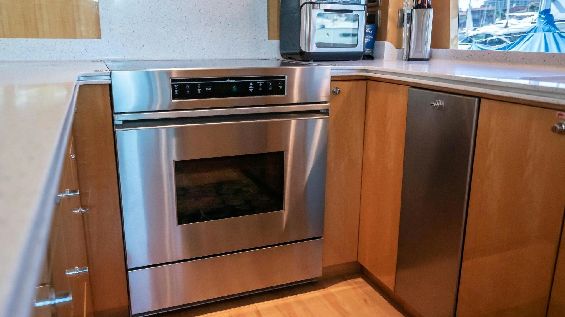 a kitchen with wooden cabinets aboard FULL HOUSE Yacht for Sale