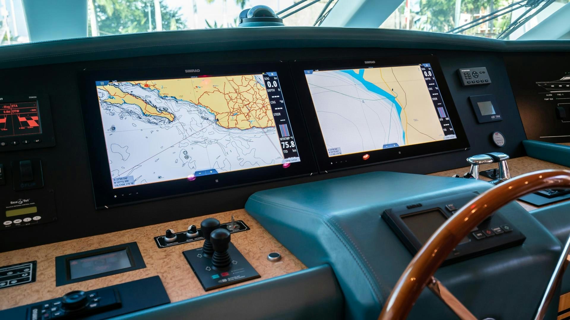 a desk with computers and a steering wheel aboard FULL HOUSE Yacht for Sale