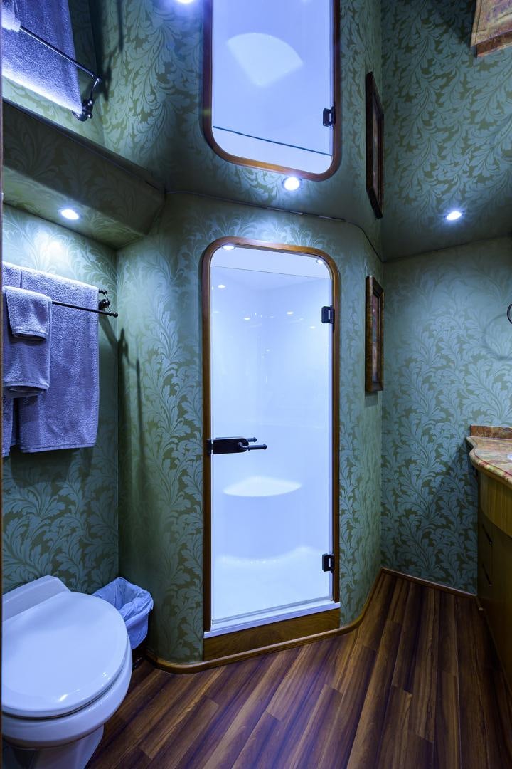 a bathroom with a toilet and a door aboard RITE ANGLER Yacht for Sale