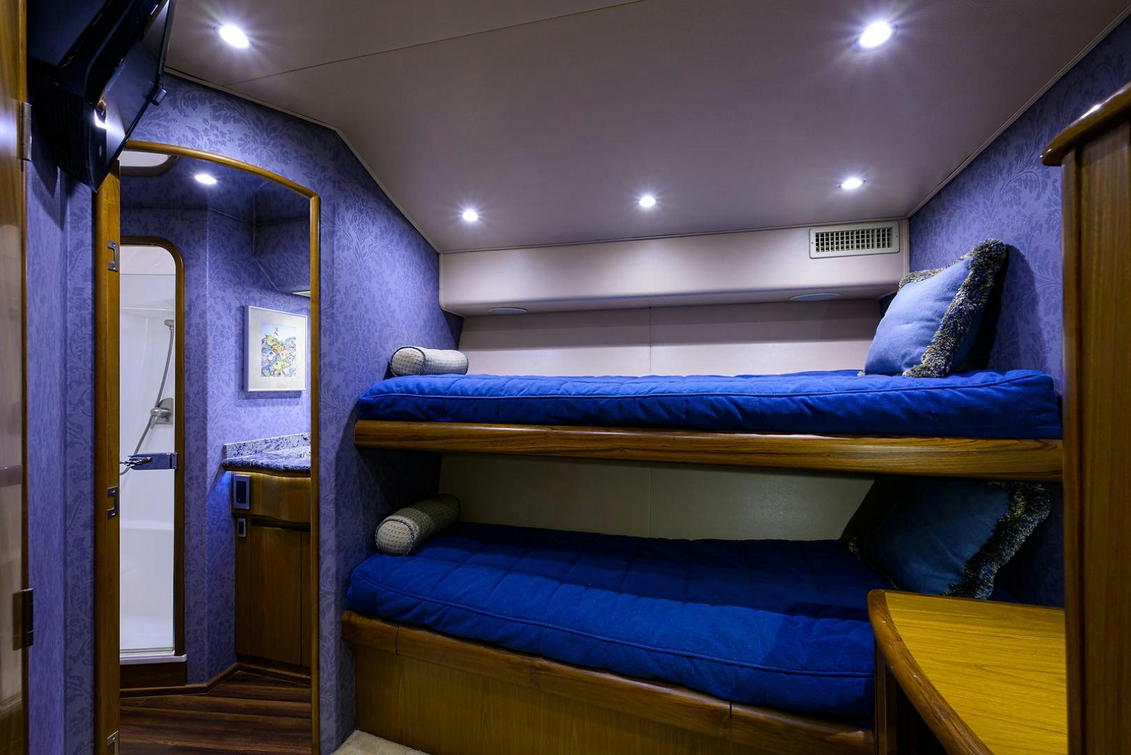 a bedroom with a blue bed aboard RITE ANGLER Yacht for Sale
