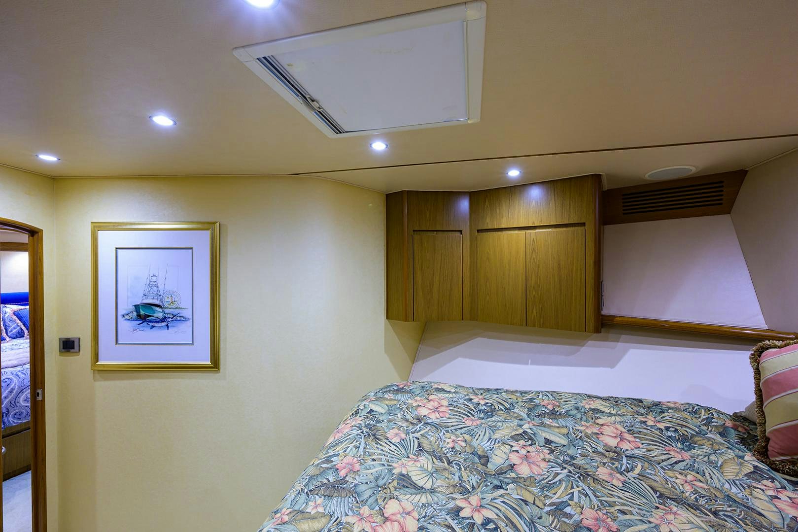 a bedroom with a bed and a wood cabinet aboard RITE ANGLER Yacht for Sale