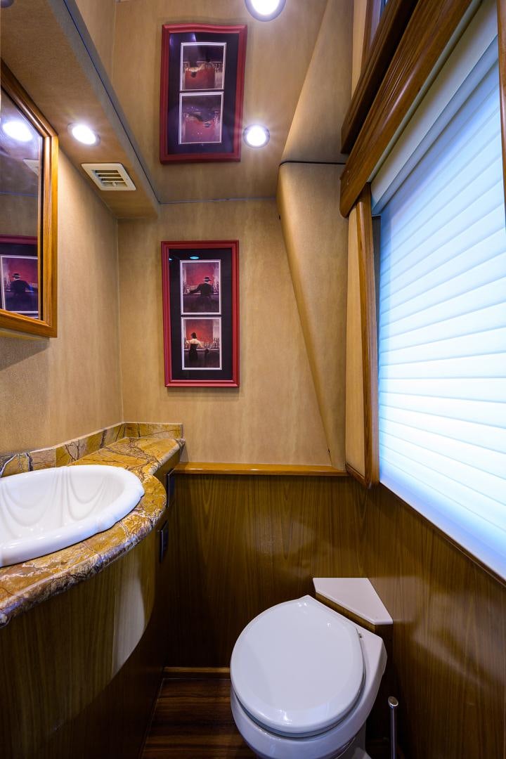 a bathroom with a sink toilet and a painting on the wall aboard RITE ANGLER Yacht for Sale