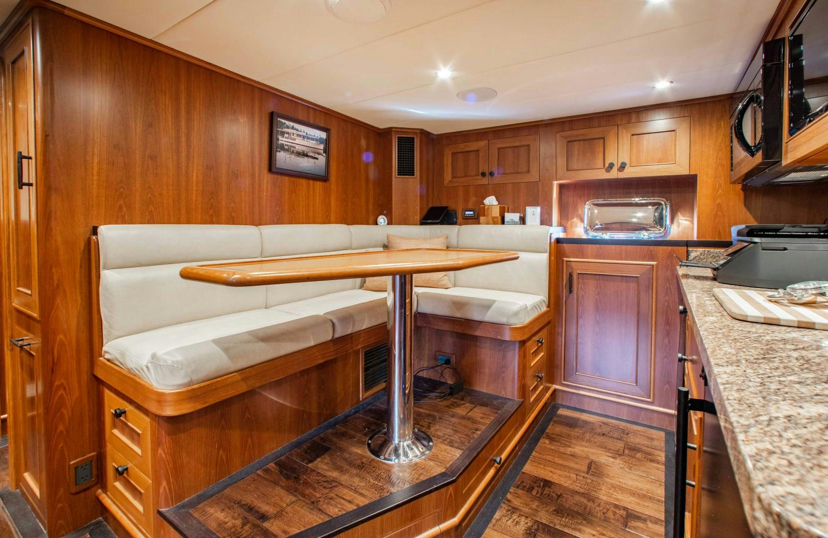 a kitchen with a table and a bench aboard BARBARA SUE II Yacht for Sale