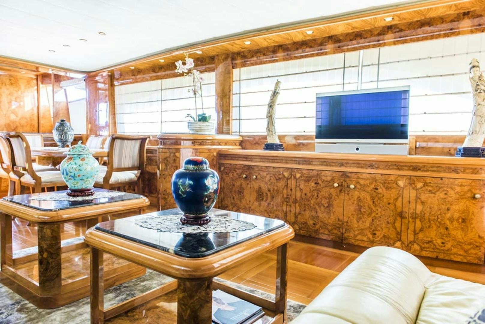 a living room with a tv and a table aboard HEMERA CUARTA Yacht for Sale