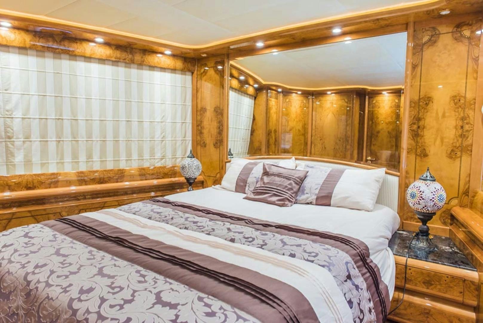 a bedroom with a bed and a mirror aboard HEMERA CUARTA Yacht for Sale