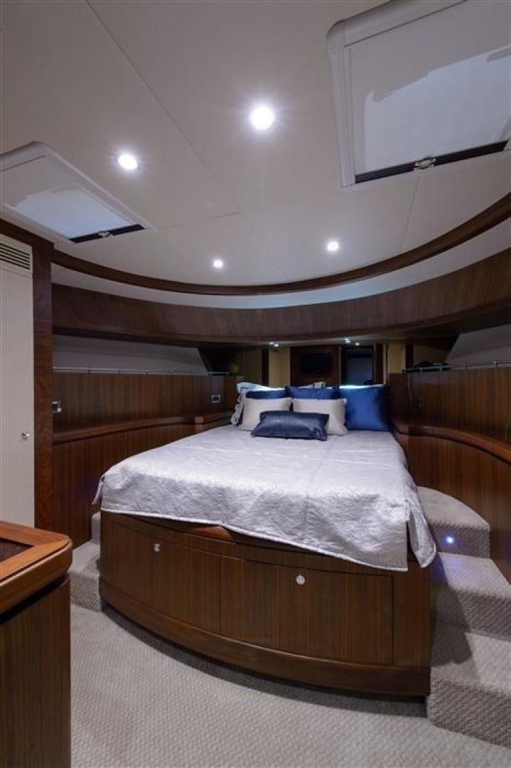 a bed with a wooden headboard aboard OCEANA Yacht for Sale