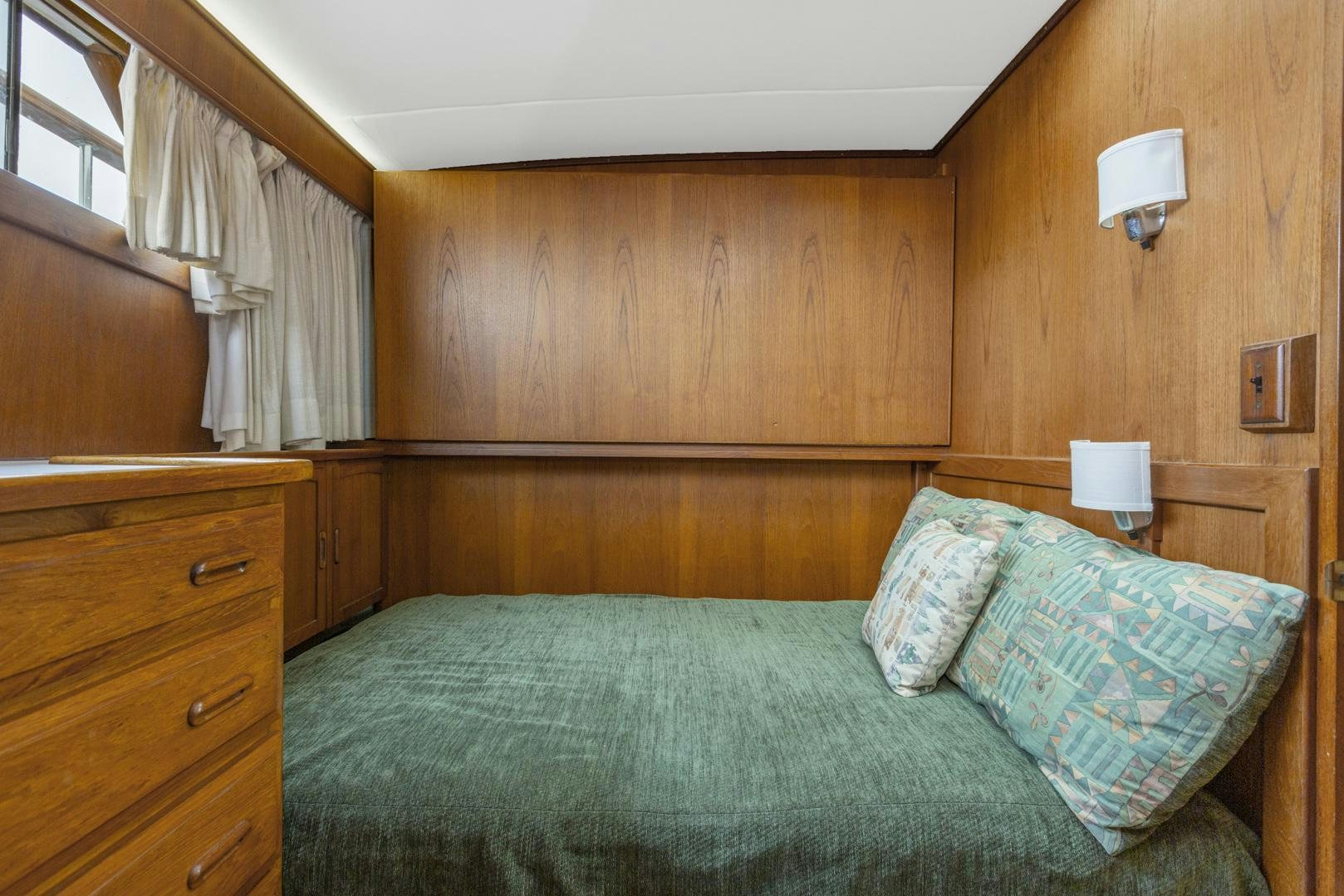 a bed with a green comforter aboard ELEGANTE Yacht for Sale