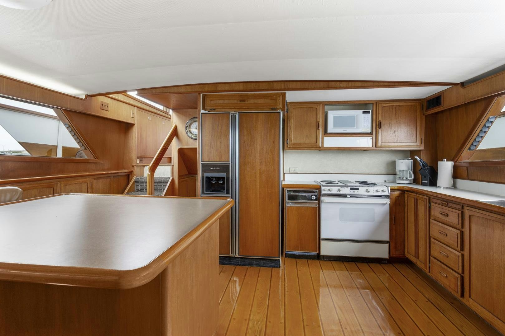 a kitchen with wooden cabinets aboard ELEGANTE Yacht for Sale