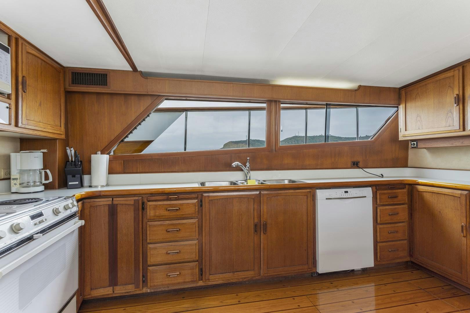 a kitchen with wooden cabinets aboard ELEGANTE Yacht for Sale