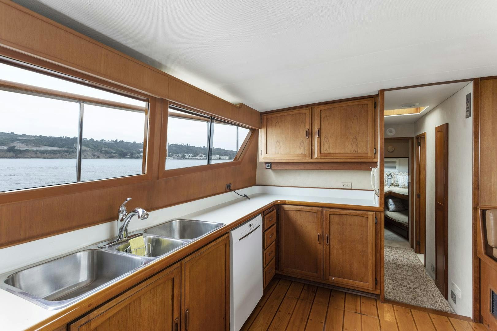 a kitchen with wooden cabinets aboard ELEGANTE Yacht for Sale
