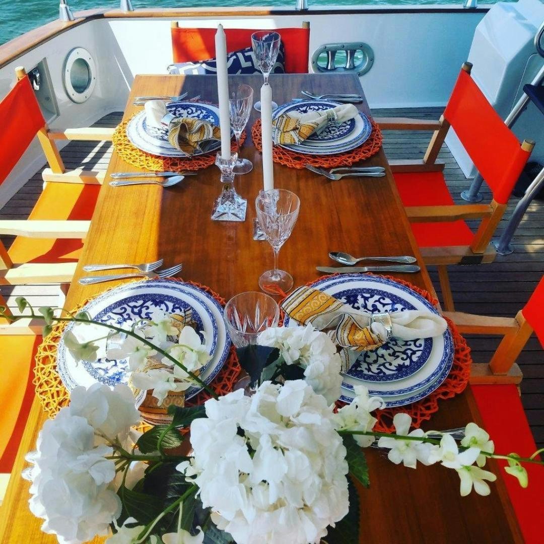 a table with plates and flowers aboard M.I.S. MOONDANCE Yacht for Sale