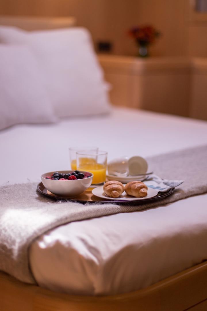 a plate of food and a glass of juice on a bed aboard MATHILDA SOUND Yacht for Sale