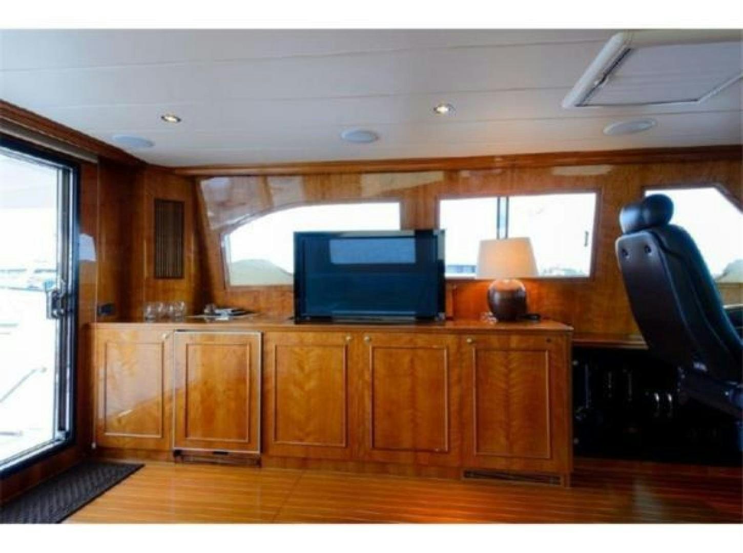a tv on a cabinet in a room with wood floors aboard PRIMETIME Yacht for Sale