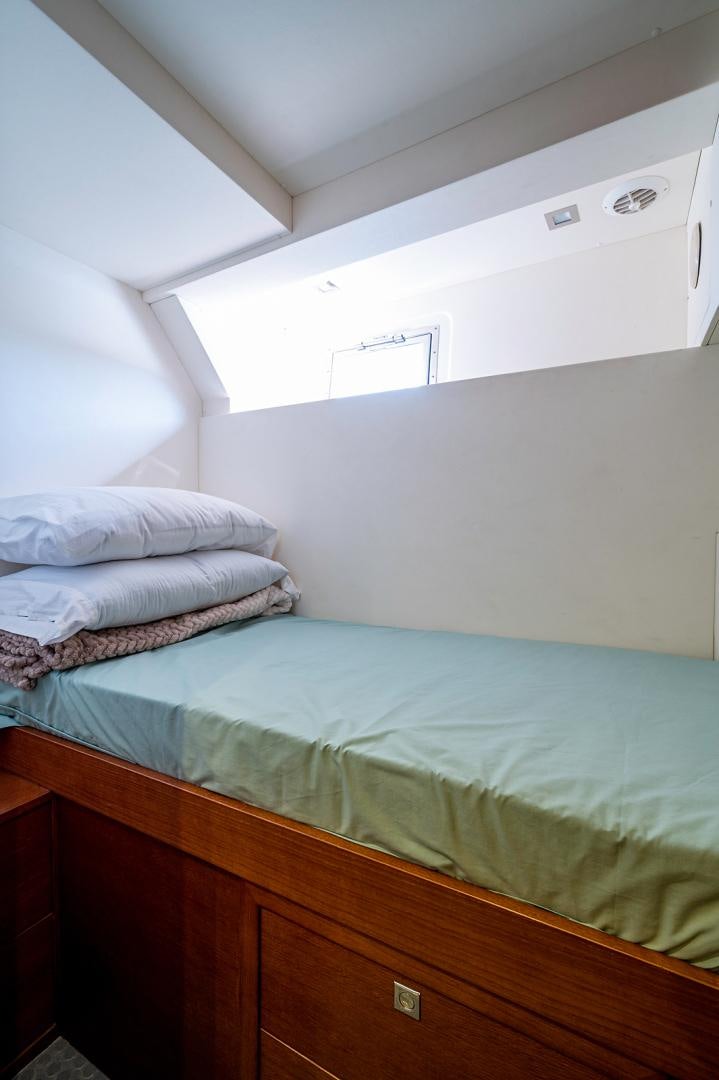 a bed with a blue comforter aboard No Name Yacht for Sale