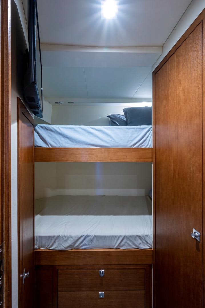 a room with a bed and a television aboard No Name Yacht for Sale