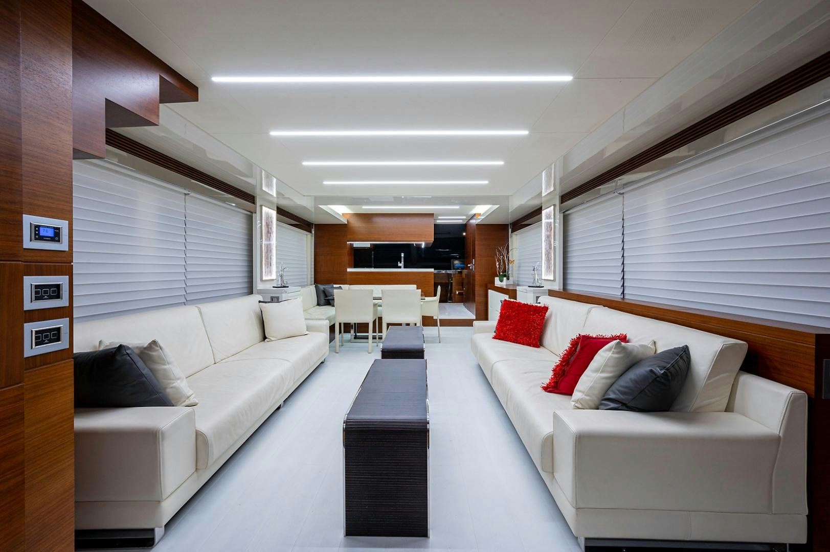 a room with white couches and a red pillow aboard No Name Yacht for Sale