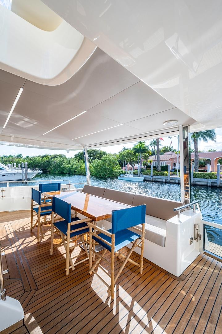 a deck with a pool and a deck with chairs and tables aboard No Name Yacht for Sale