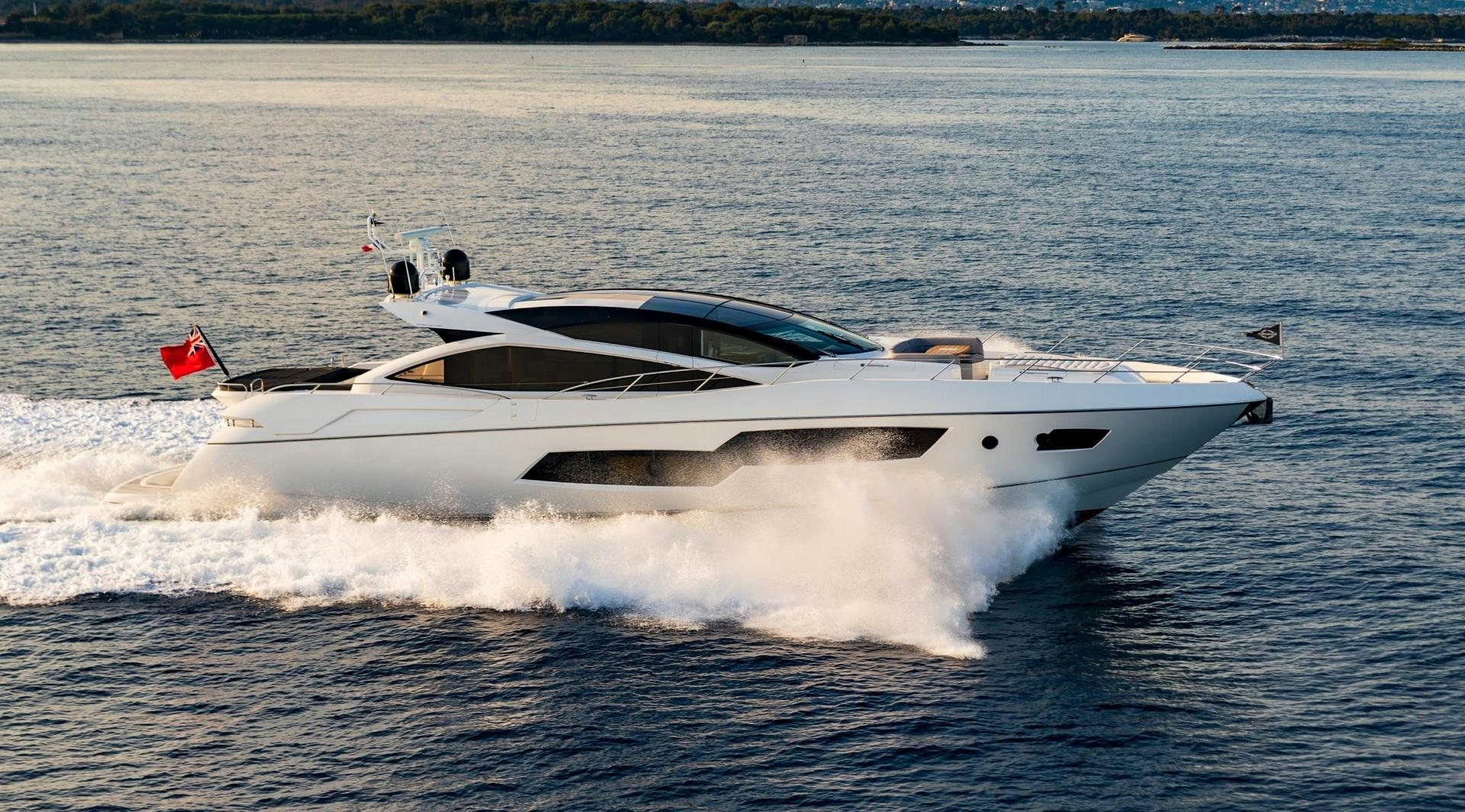 a white yacht with a red and black tail splashing in the water aboard SKYFALL Yacht for Sale