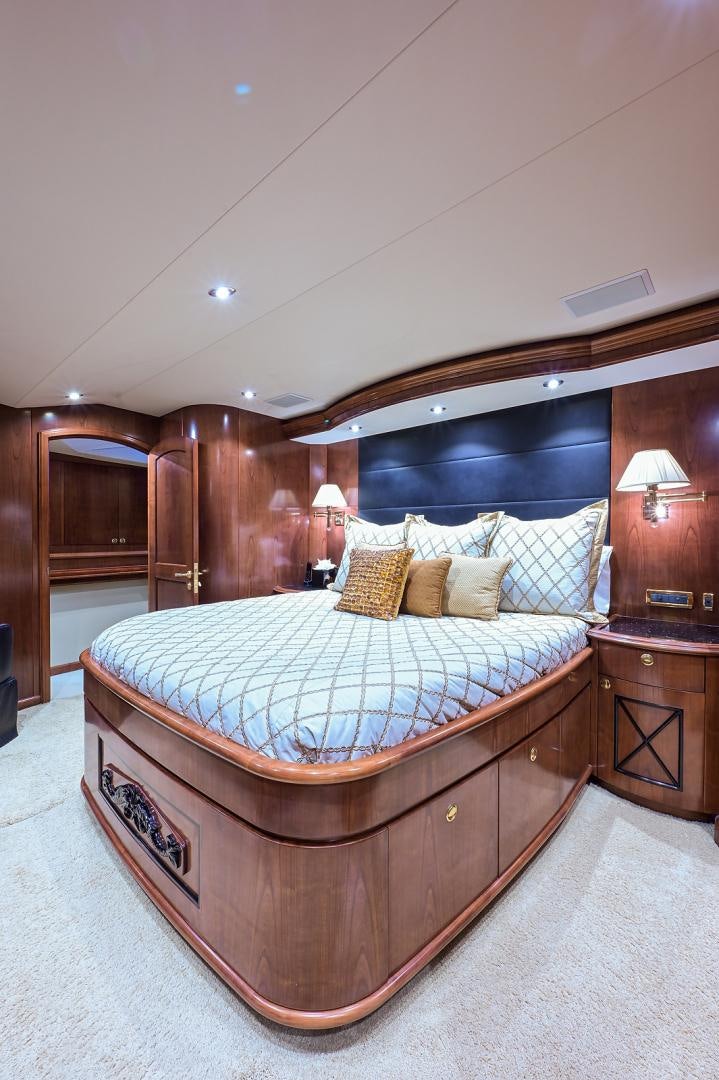 a bed with a blue and white comforter and pillows aboard BLACK SHADOW Yacht for Sale