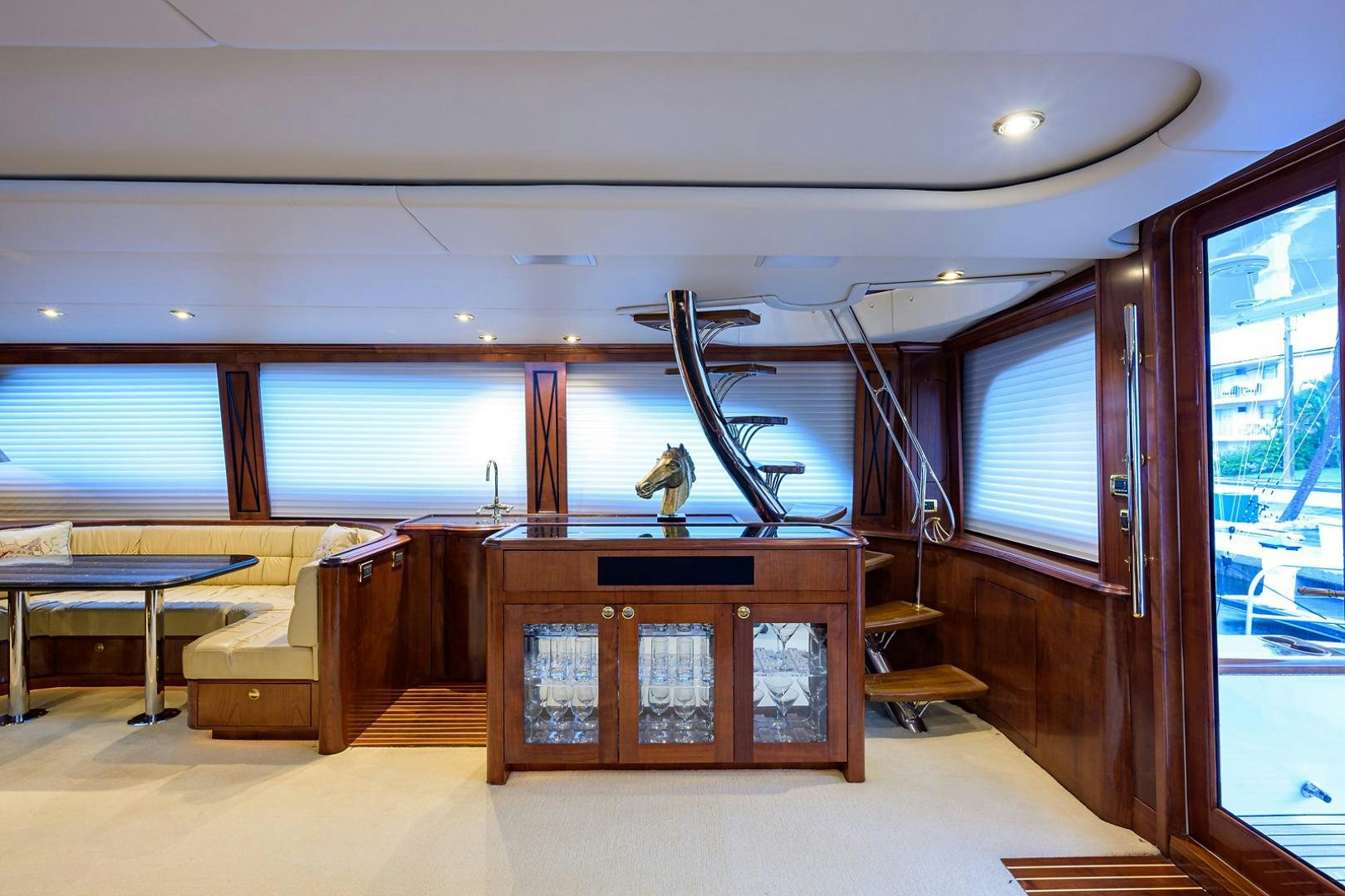 a room with a wood cabinet and a table and chairs aboard BLACK SHADOW Yacht for Sale