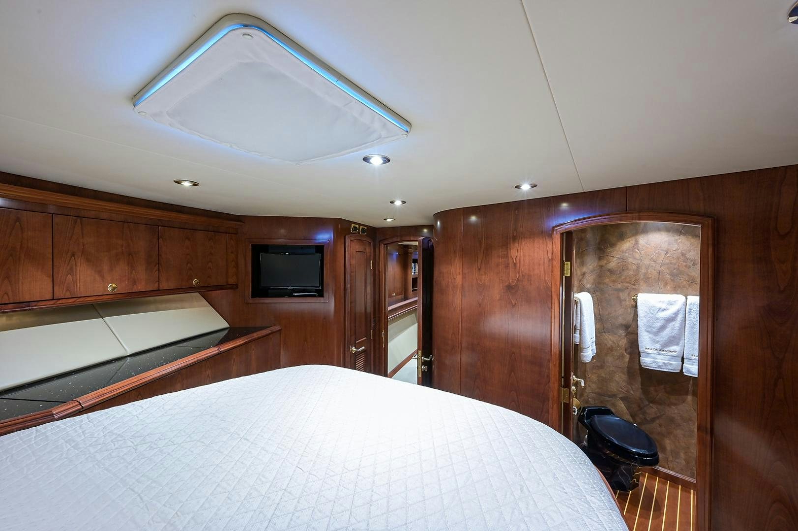 a room with a bed and a television aboard BLACK SHADOW Yacht for Sale